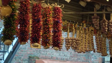 close up slow motion shot of a bunch of spices, peppers, and garlic hanging from the ceiling in the street market of pike place in seattle washington