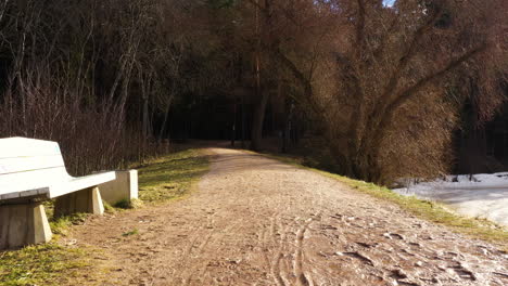 Muddy-path-with-bench-along-Gauja-river-outside-Valmiera,-Latvia