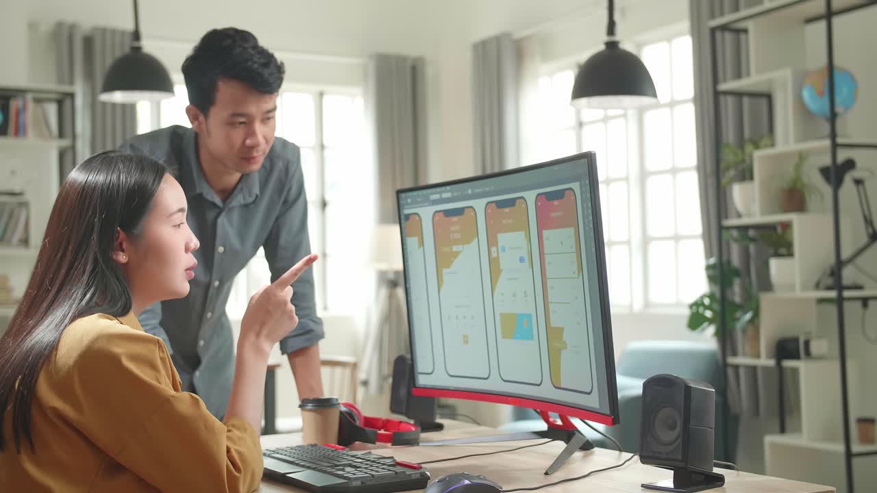Worried Unhappy Asian Male And Female Mobile Application Designers Arguing And Discuss New App Features. They Work On A Personal Computer