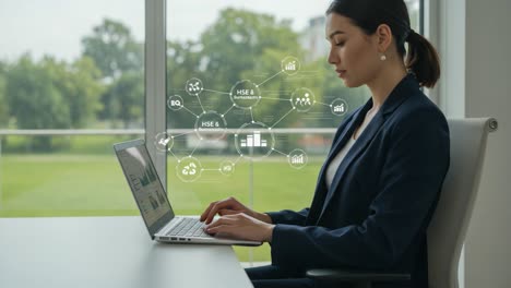 a professional woman engaging with data visualization on a laptop while exploring hse insights and connections in a bright office environment