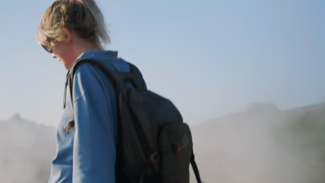 una mujer caminando por las montañas de niebla.