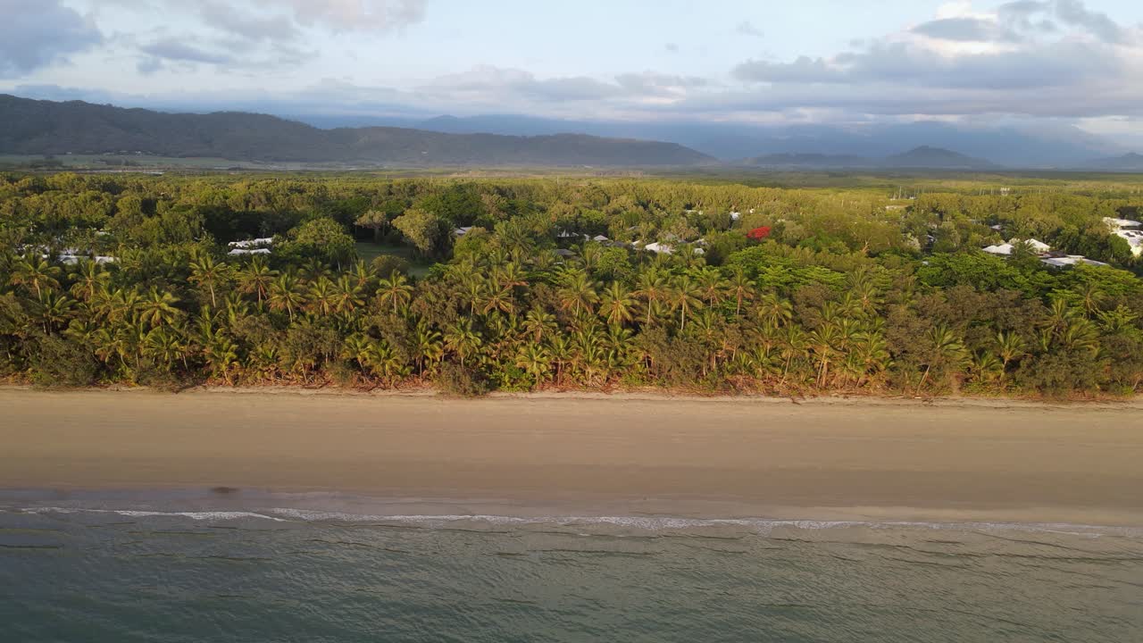 la playa de cuatro millas bordeada de palmeras y las cadenas montañosas cubiertas de selva tropical del daintree