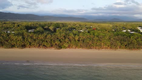 Playa-De-Cuatro-Millas-Bordeada-De-Palmeras-Y-Las-Cadenas-Montañosas-Cubiertas-De-Selva-Tropical-De-Daintree