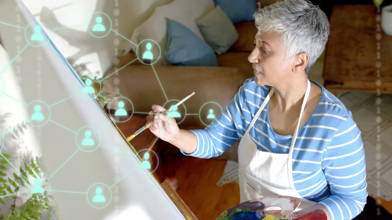 Female painter painting at easel, dipping brush and causing data tech overlay while checking layout