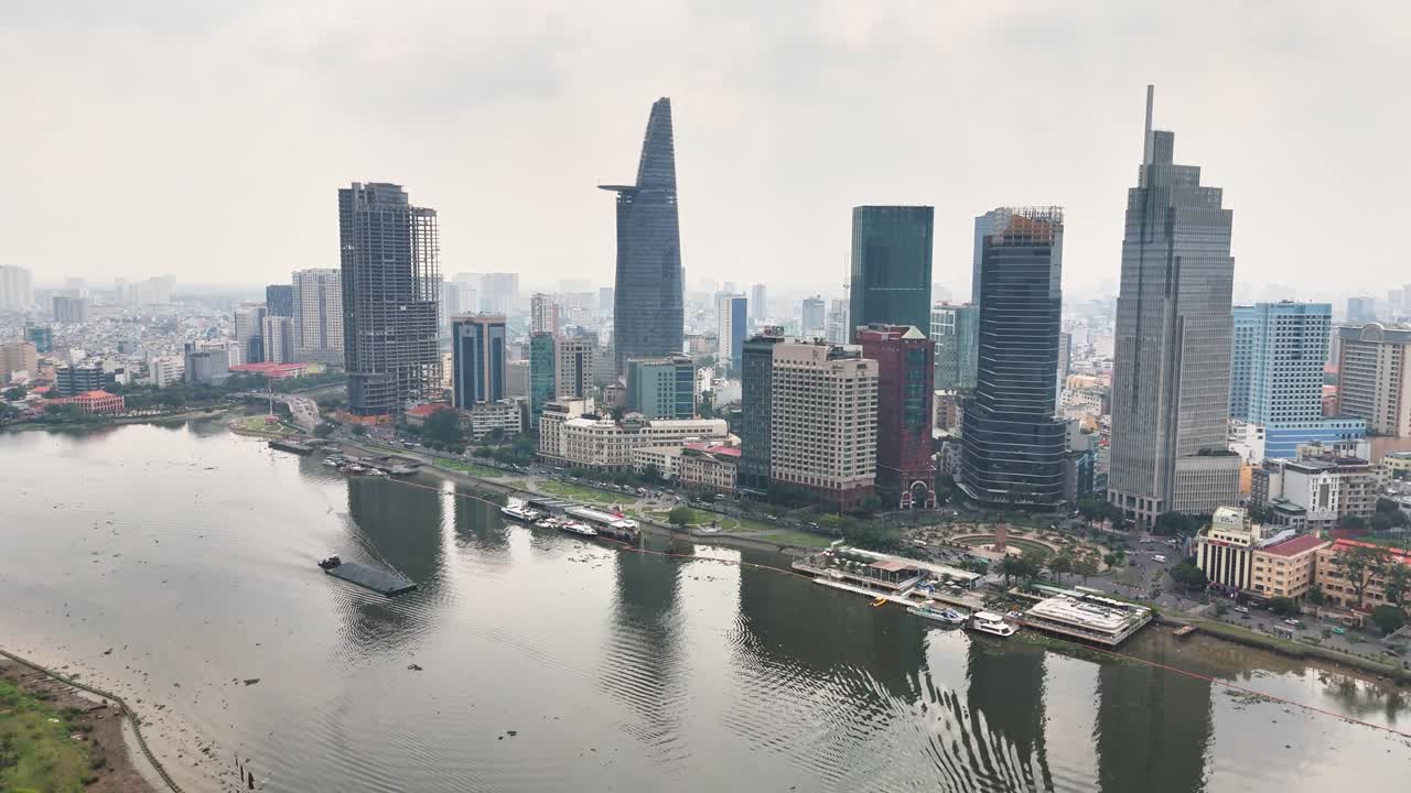 Vietnam'ın merkezi Ho Chi Minh Şehri üzerinde drone görüntüsü; Saygon Nehri ve Bitexco Finans Kulesi ile Landmark 81'in parlak gün ışığı altında suda yansıdığı ikonik silüet.