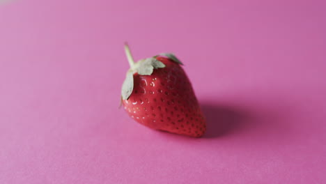 video of strawberry with copy space over pink background