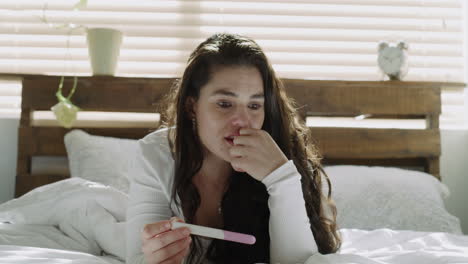 woman anxiously looking at pregnancy test result