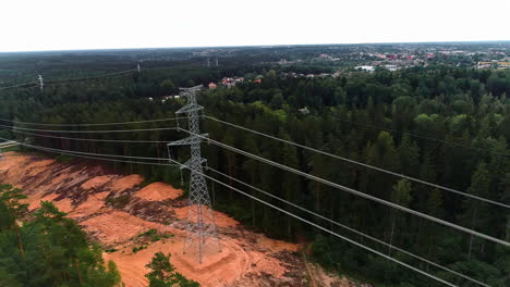 aerial drone pan shot from left to right over newly installed electric pole surrounded by dense forest on a cloudy day