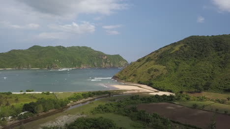 Low-aerial-Ocean-surf-breaks-around-point-onto