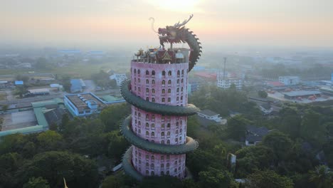 imágenes cinematográficas de 4k sunrise que recorren el templo de wat samphran con un enorme dragón enrollado y protegiéndolo en la provincia de amphoe sam phran en bangkok, tailandia