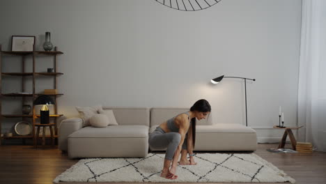 woman doing yoga squat pose at home