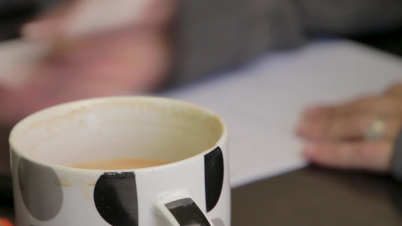 mujer escribiendo algo en un trozo de papel con un marcador inclinado.