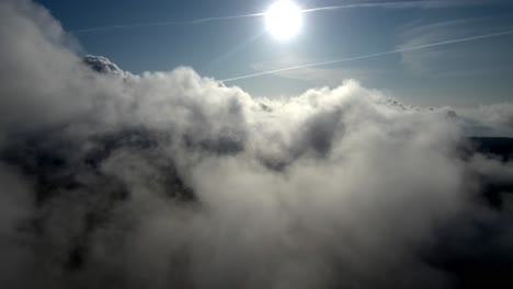 aerial view of sun shining above fluffy white clouds