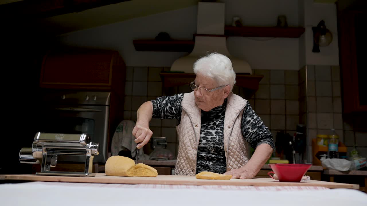 mujer de edad amasar la masa en la cocina