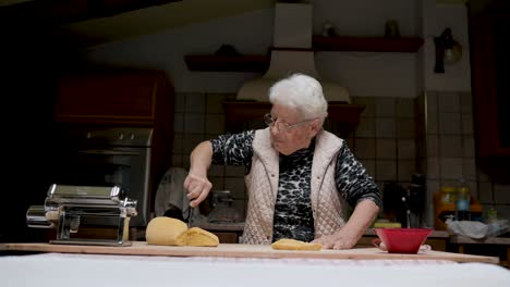 Aged-woman-kneading-dough-in-kitchen