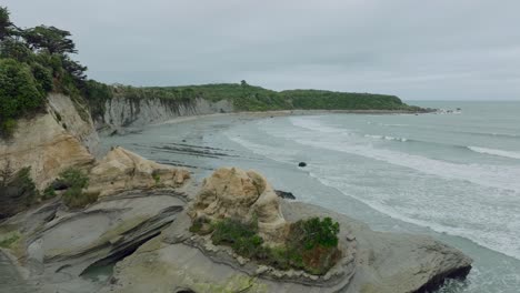 Vuelo-Aéreo-Con-Drones-Sobre-El-Crudo,-Salvaje-Y-Accidentado-Paisaje-Costero-De-Los-Acantilados-De-Omau-En-Cabo-Foulwind-En-La-Costa-Oeste-De-La-Isla-Sur,-Nueva-Zelanda-Aotearoa