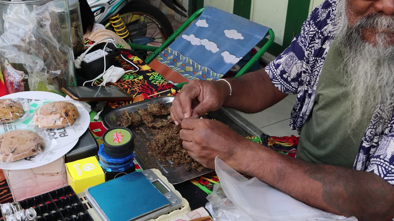 hombre anciano creando patrones de batik en la tela