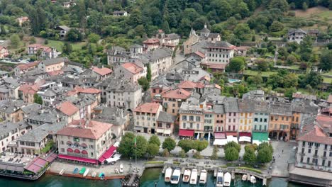 이탈리아 오르타 호수에 있는 산 줄리오 섬 (isola di san giulio) 에서 역사적인 건물과 배를 전시하고 있다.