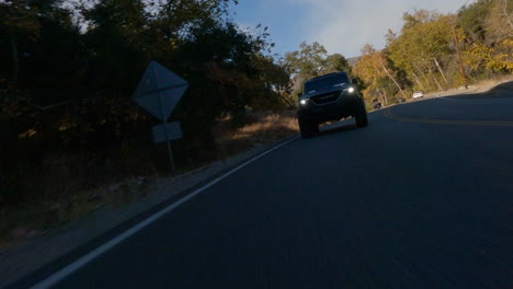 Fpv-drone-view-of-black-car-driving-fast-on-road