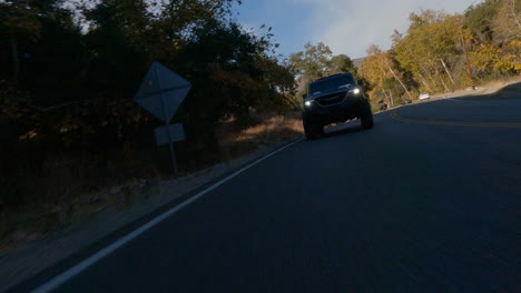 fpv drone vista de coche negro conduciendo rápido en la carretera