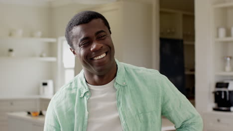 in kitchen, man smiling while preparing meal, enjoying lighthearted moment at home
