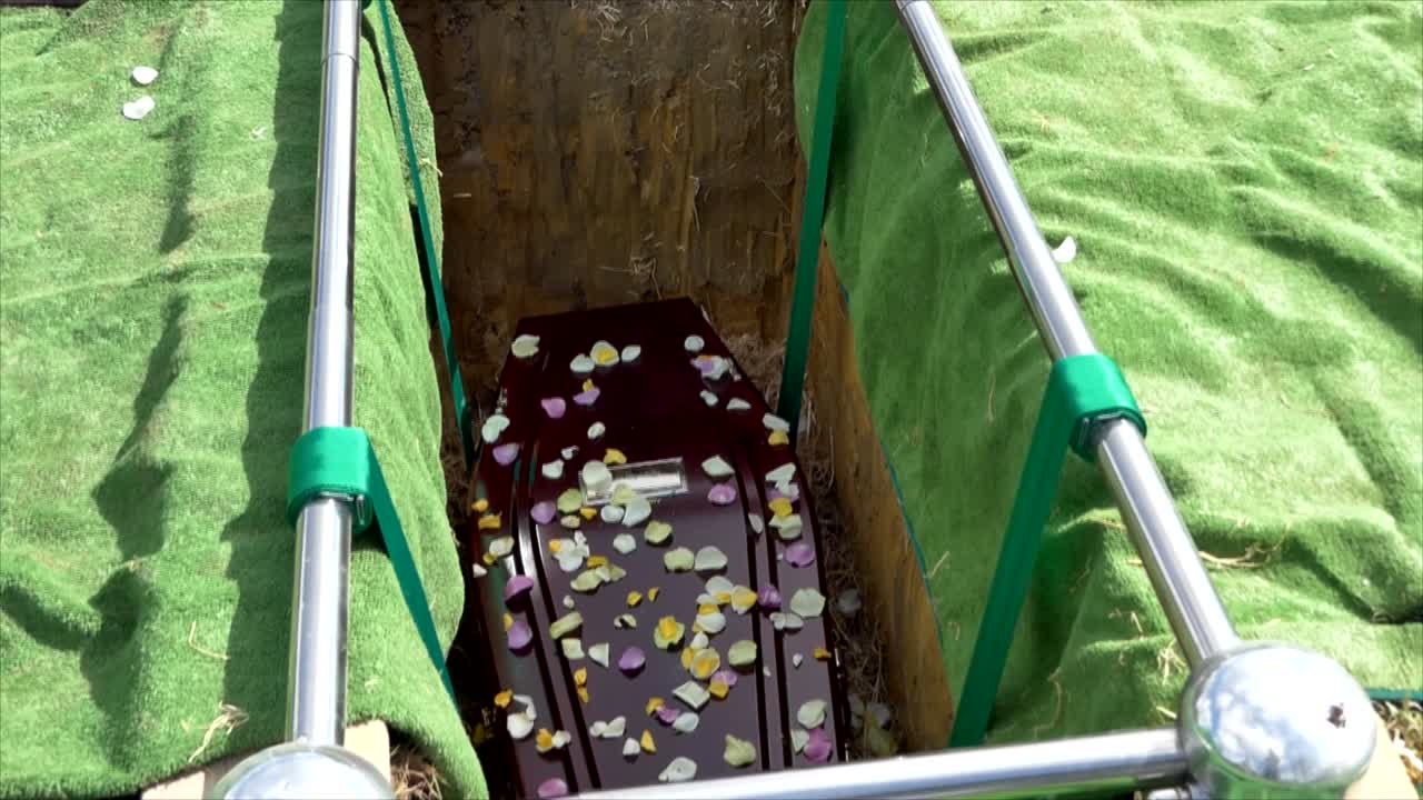 closeup shot of a funeral casket in a hearse or chapel or burial at cemetery