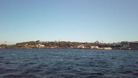 evening, cinematic slow-mo, a mesmerizing view of sarayburnu from a ferry on the golden horn in istanbul