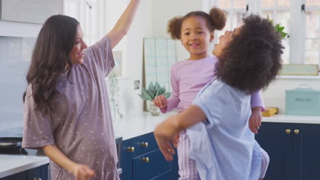 Familia-Embarazada-Con-Dos-Mamás-Bailando-Haciendo-Panqueques-Matutinos-En-La-Cocina-Con-Su-Hija