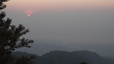 Sonnenaufgang-Mit-Schicht-Aus-Nebligen-Bergen,-Baum-Im-Vordergrund,-Doi-Pha-Hom-Pok,-Thailand