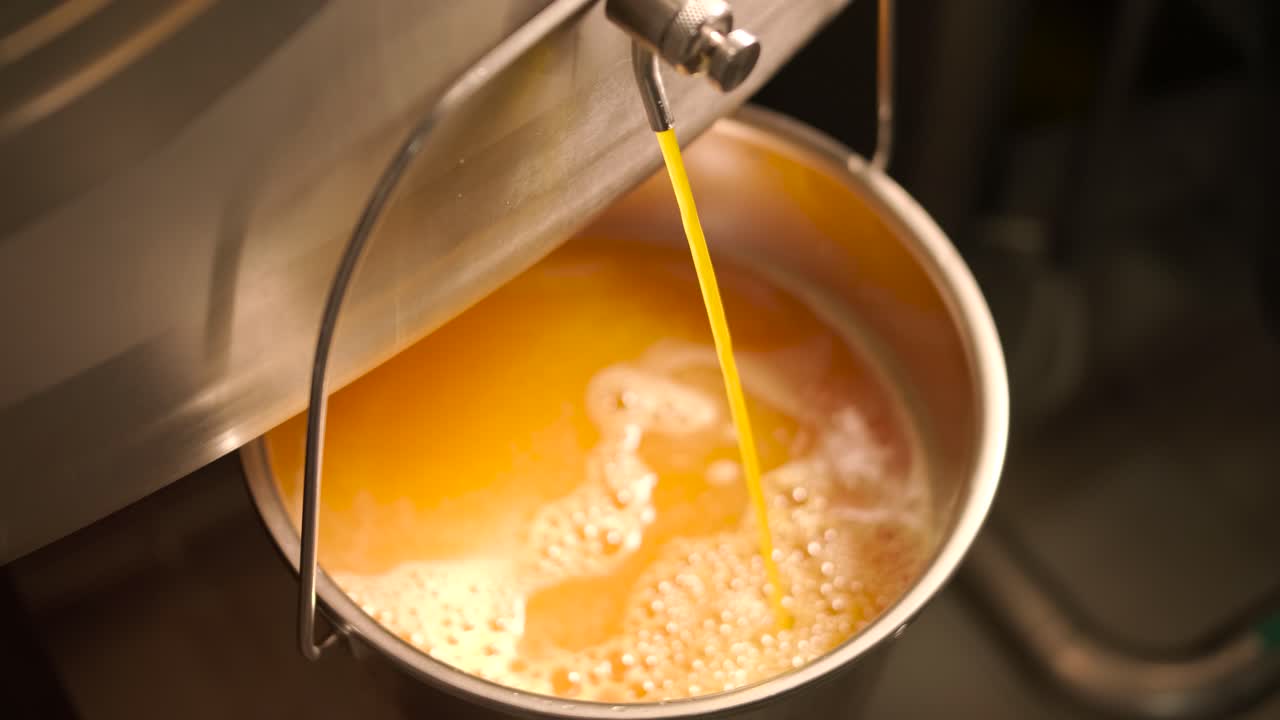Orange juice being poured into a bucket
