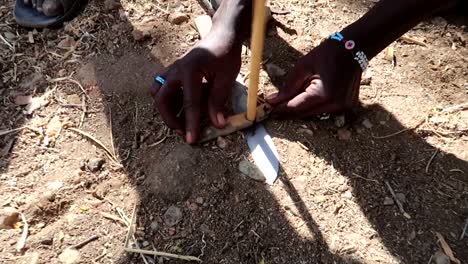 hadzabe tribe teaching how to make fire with wooden stick and a knife