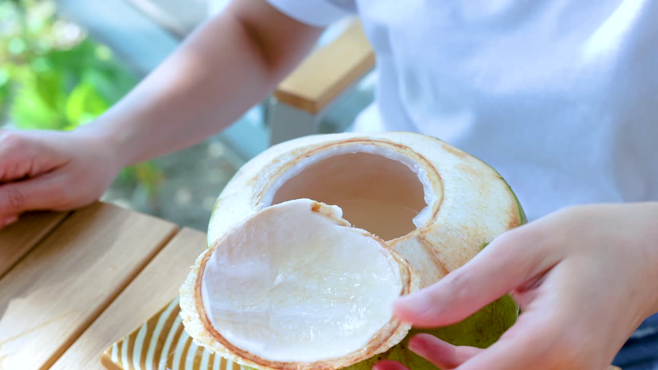 persona recogiendo carne de coco con una cuchara