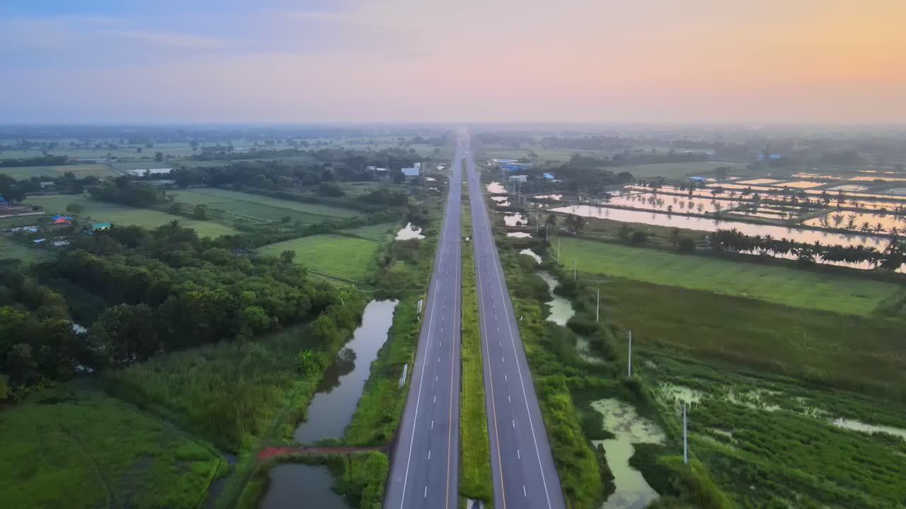 공중: 드론이 비현실적인 새벽에 고속도로 위로 대칭적으로 고도를 높이고 있습니다.