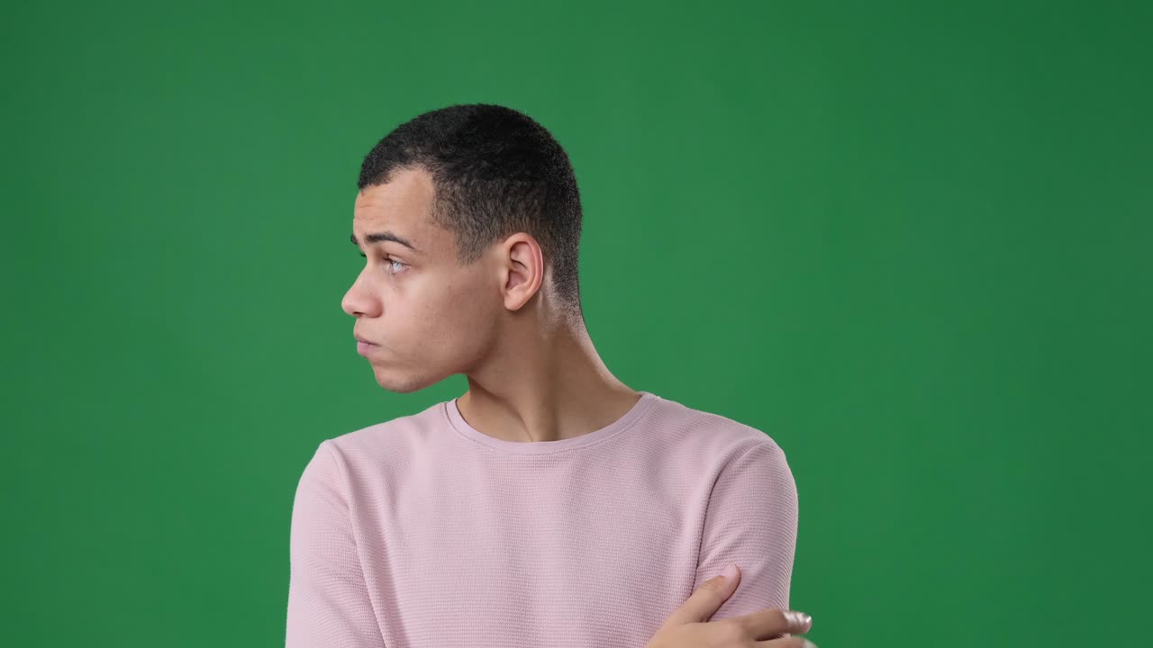 Uomo impaziente che aspetta e controlla l'ora su sfondo verde