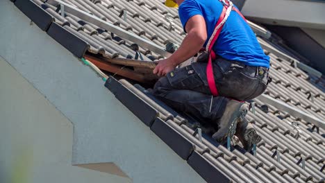 close-up van reparateur, die de tegels op het dak van de hut bevestigt