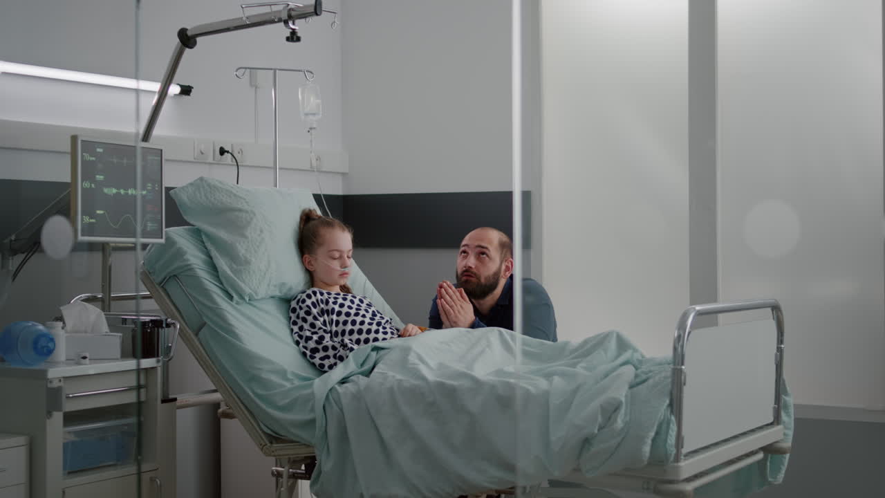 Worried sad father holding hands together praying while waiting sickness diagnose