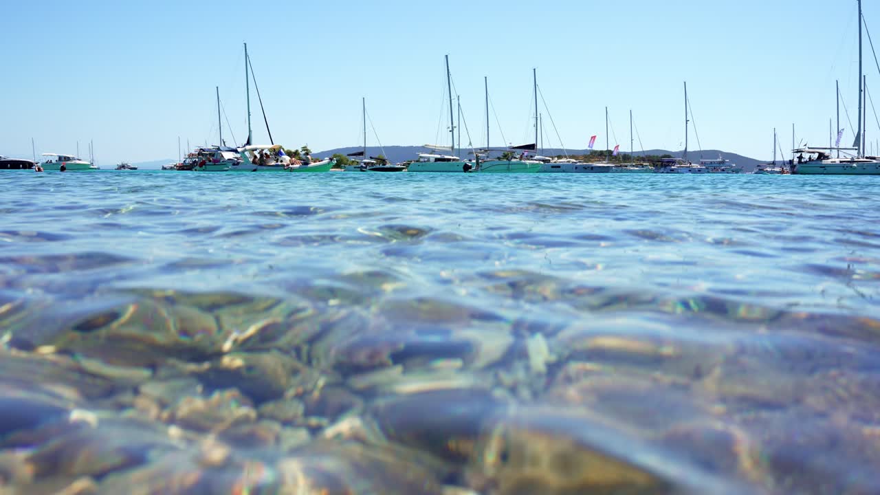 Vista divisa sul mare blu con barche e riflessi di luce solare