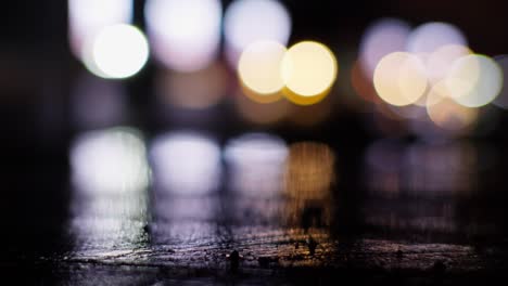 night's wet canvas, streetlights reflecting on rainy roads