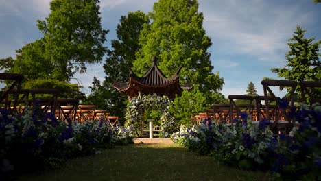 a view of a beautiful wedding reception set up in a lush garden, captured in the soft light of a lovely day