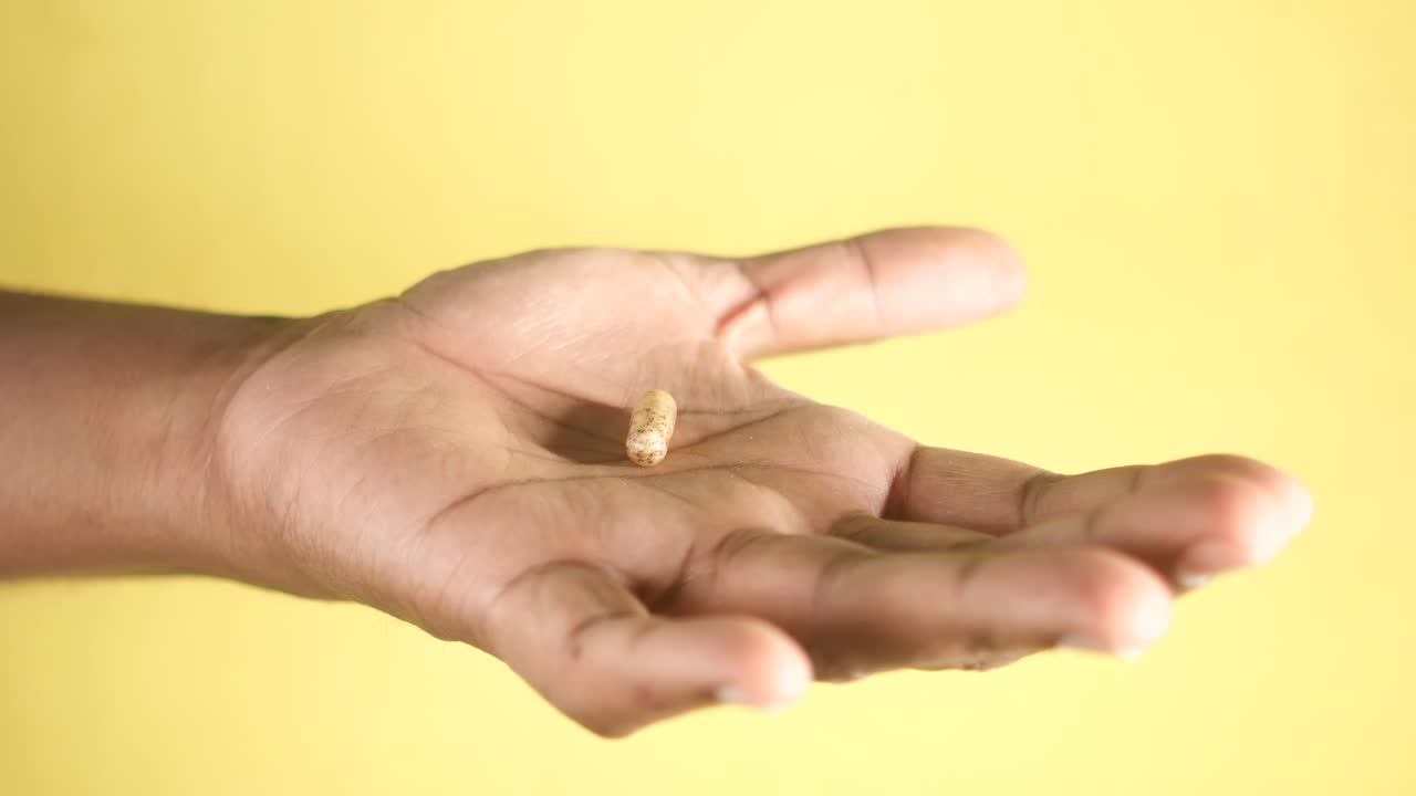 Close-up of hands, showing an open palm and holding a small object
