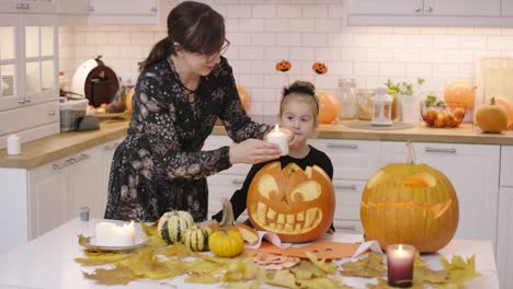 woman putting candle into jack o lantern