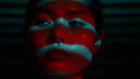 dramatic close-up portrait with red and cyan light stripes
