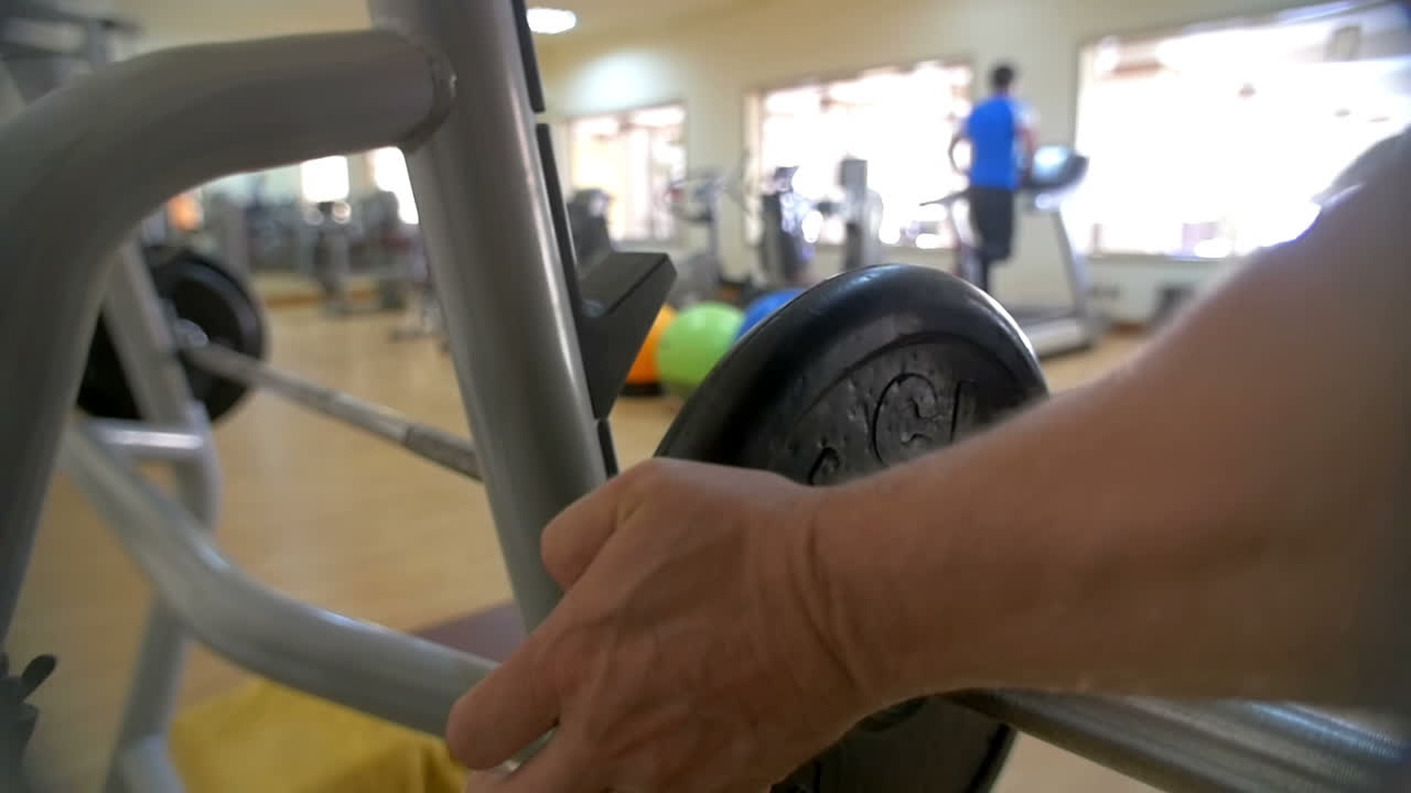 Man increasing weight on barbell