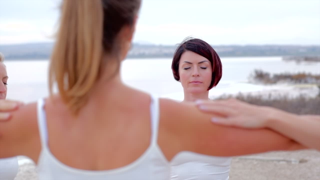 한 무리의 여성들이 야외에서 함께 명상을 합니다.