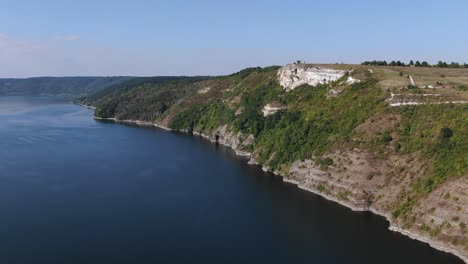 aerial view of a cliff overlooking a river on a bright sunny day