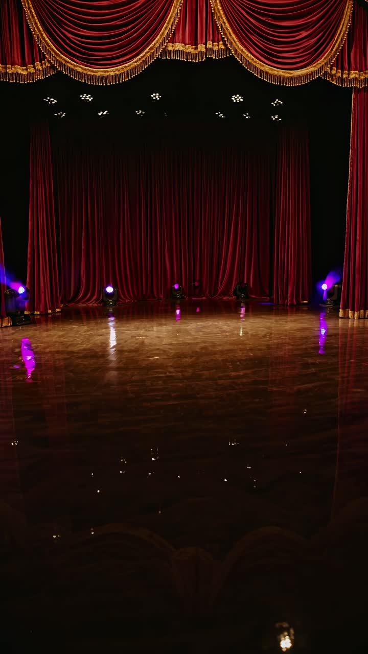 A dramatic stage setup with purple curtains and spotlights, captured from a low angle