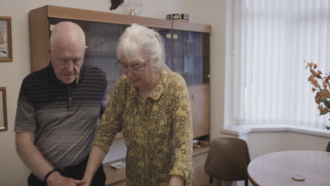 elderly couple using walker with assistance