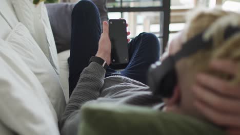 albino african american man with dreadlocks using smartphone