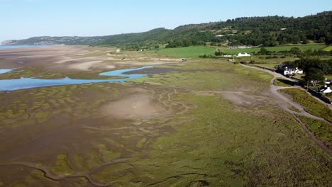 Aerial-descending-view-Traeth-Coch-scenic-salt-marsh-moorland-countryside-at-sunset