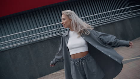 joyful woman model posing in casual clothes at city buildings.